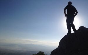 Silhouette d'un Homme au sommet d'une montagne, regardant à 180° autour de lui